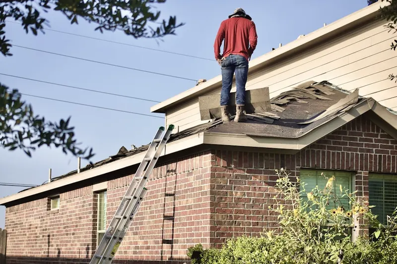 Professional roofer working on a residential roof in Haller Lake